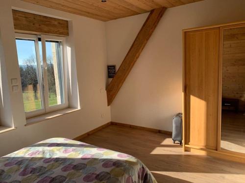 a bedroom with a bed and a large window at Gîte de Lagattau en pleine nature in Villers-le-Lac
