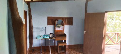 a room with a wooden table and a mirror at Billy the Homestay in Chiang Dao