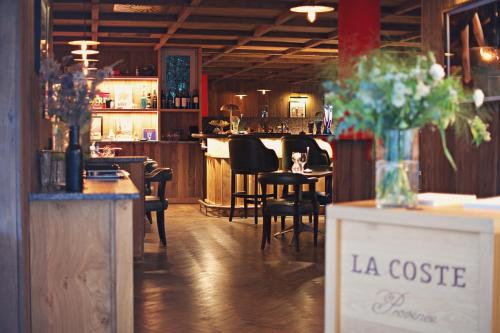 un restaurant avec un bar avec une table et des chaises dans l'établissement Auberge La Coste, à Le Puy-Sainte-Réparade