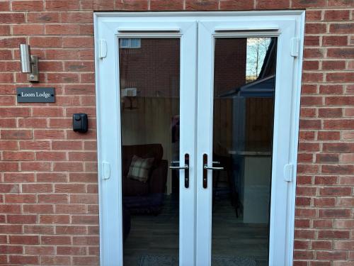 a pair of french doors in a brick building at Loom Lodge in Great Wyrley