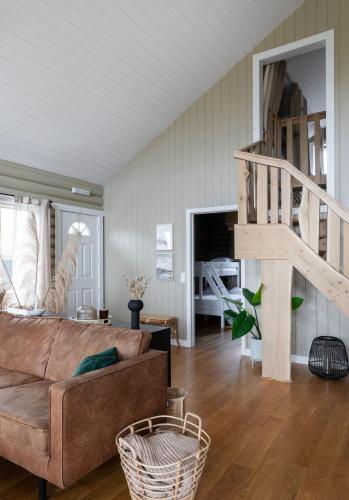 a living room with a couch and a staircase at The Eyrie - Luxurious Cabin in the Golden Circle in Úthlid