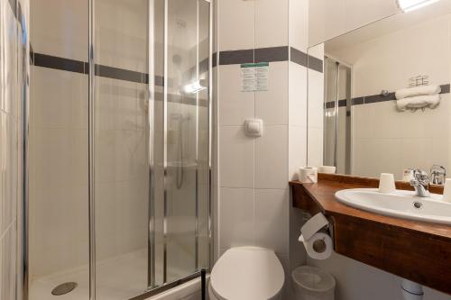 a bathroom with a shower and a toilet and a sink at HÔTEL ÉDEN - Metz Nord - Woippy - Porte du Luxembourg - A31 in Woippy