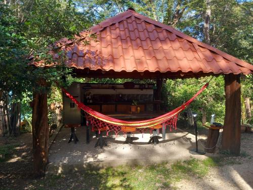 a gazebo with a red roof and a hammock at Aura Bungalow 2 in Tamarindo