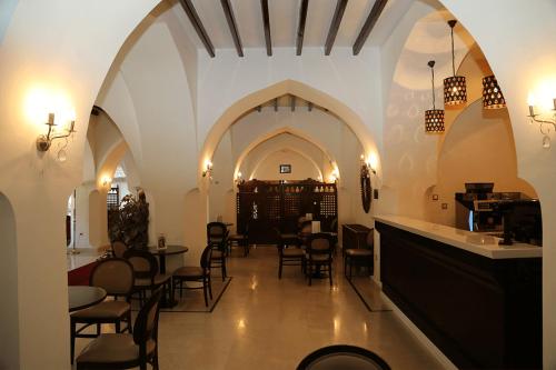 a restaurant with chairs and tables in a room at Le Caid Hotel in Bou Saâda