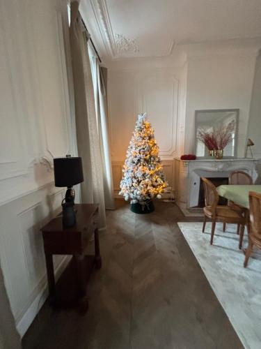 a christmas tree in a living room with a table at Hôtel Particulier Petit-Decaix in Conty