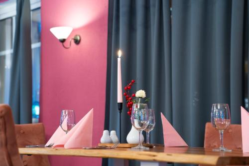 a table with wine glasses and a candle on it at Berghotel Drei Brüder Höhe in Marienberg