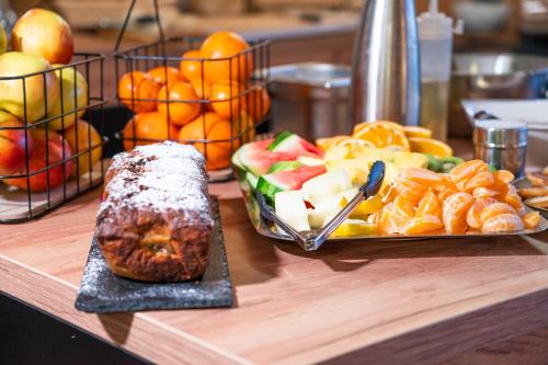 a table with a plate of fruit and a plate of bread at Berghotel Drei Brüder Höhe in Marienberg