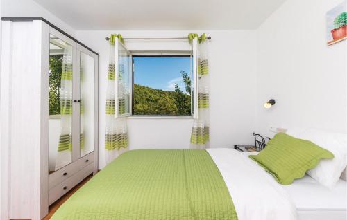 a white bedroom with a green bed and a window at Two-Bedroom Holiday Home In Trilj in Trilj
