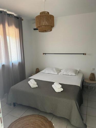 une chambre avec un lit avec deux serviettes dessus dans l'établissement Appartement Cosy à Lecci , Porto Vecchio, à Lecci