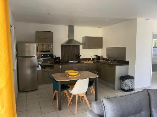 une cuisine avec une table et des chaises en bois ainsi qu'une table et une cuisine avec dans l'établissement Appartement Cosy à Lecci , Porto Vecchio, à Lecci