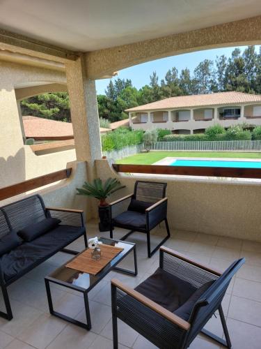 une terrasse avec des chaises, une table et une piscine dans l'établissement Appartement Cosy à Lecci , Porto Vecchio, à Lecci