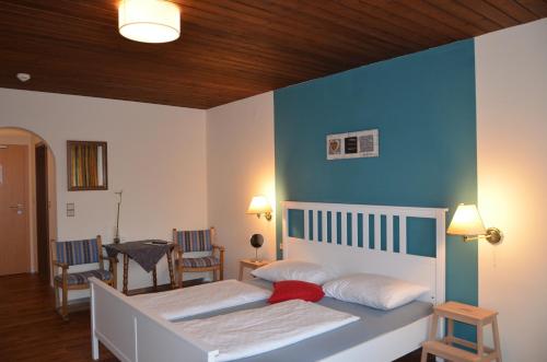 a bedroom with two beds and a blue wall at Dahoam by Sarina - Rooms & Suites in Zell am See