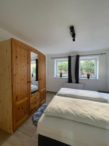 a bedroom with a large bed and two windows at Ferienhaus - Eifeltraum - Salm in Salm