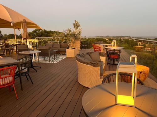 a deck with tables and chairs and tables and tablesearcher at MGB Hotel at 2ten in Thohoyandou