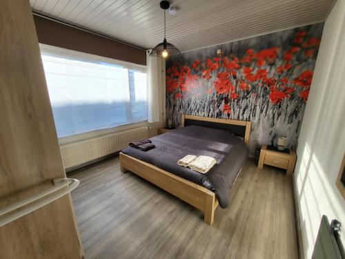a bedroom with a bed and a painting on the wall at Mary's Poppies - Bed & Breakfast in Blandain