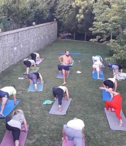 a group of people doing yoga in the grass at Hotel Aroma in Përmet