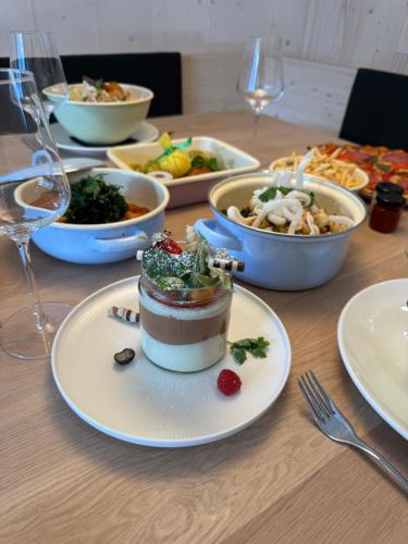 a table topped with plates of food and glasses of wine at Mariengut - Natur Aparthotel Kramer in Wagrain