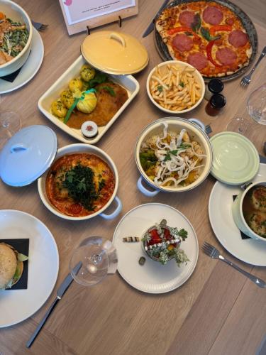 a table with many plates of food on it at Mariengut - Natur Aparthotel Kramer in Wagrain