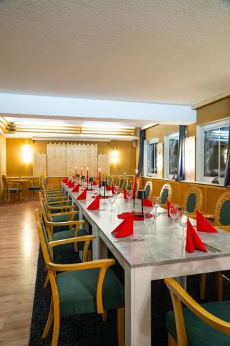 a long table with red napkins and chairs in a room at Berghotel Drei Brüder Höhe in Marienberg