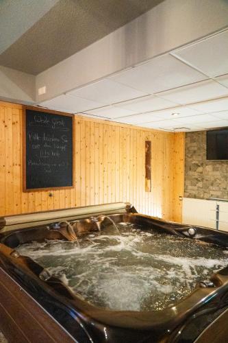 a hot tub in a room with a chalk board at Berghotel Drei Brüder Höhe in Marienberg