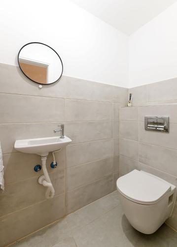 a bathroom with a toilet and a mirror and a sink at פנטאוז עצום נוף עוצר נשימה in Qiryat Yam