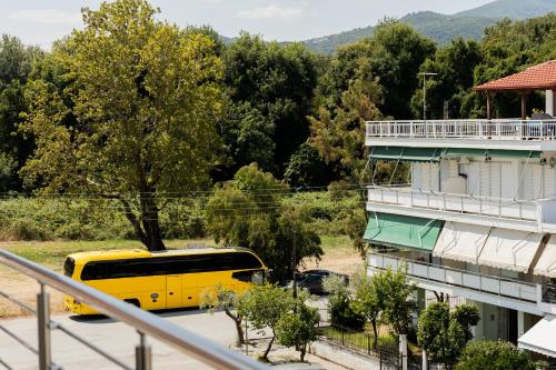 a yellow bus parked in a parking lot next to a building at Tommys Apartment in Nei Poroi