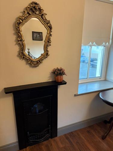 a mirror on a wall above a fireplace at The Blue Door in Castleisland