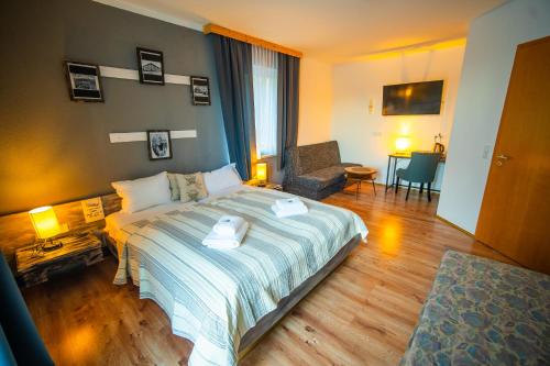 a bedroom with a bed with two towels on it at Berghotel Drei Brüder Höhe in Marienberg