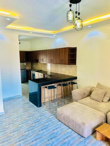 a living room with a couch and a kitchen at Dash apartment No 1 - Quartier miroir in Bujumbura