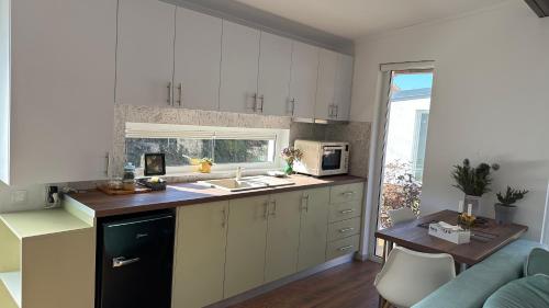 Una cocina con gabinetes blancos y encimera. en Oaza de liniște Olănești, en Valea Cheii