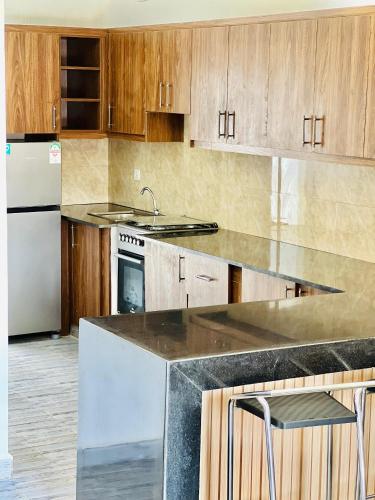 a kitchen with wooden cabinets and stainless steel appliances at Dash apartment No 1 - Quartier miroir in Bujumbura