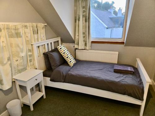a small bedroom with a bed and a window at Achnamara-Self Check In in Portree
