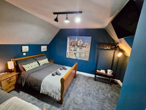 a bedroom with a bed and a blue wall at Achnamara-Self Check In in Portree