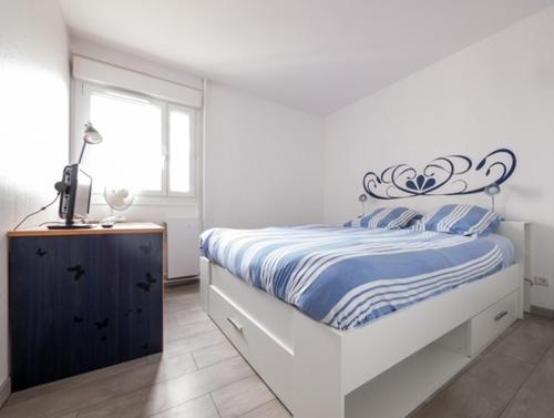 une chambre blanche avec un lit et une fenêtre dans l'établissement Lhuisne, au Mans