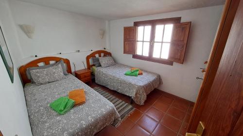 ein kleines Zimmer mit zwei Betten und einem Fenster in der Unterkunft Remarkable 3-bedroom house 'Villa' Finca Vistamar in Salobre