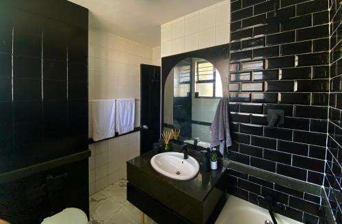 a black and white bathroom with a sink and a mirror at 10 South Ocean Views in Durban