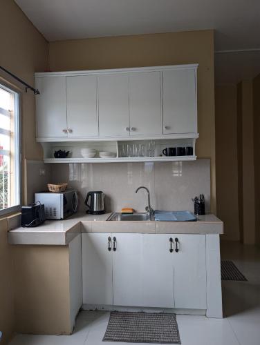a kitchen with white cabinets and a sink at L'islo INN in Davao City