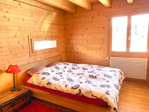 a bedroom with a bed in a log cabin at La Pourvoirie - 4 Vallées - Thyon-Les Collons, 10 personnes, pistes de ski à 200m, vue magnifique ! in Hérémence