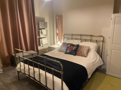 a bedroom with a metal bed with pillows on it at Central London Spitalfields Apartment in London