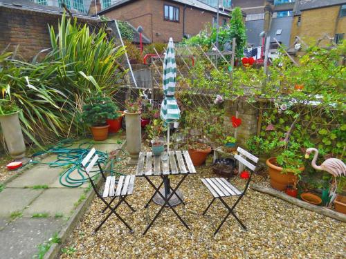 a garden with chairs and a table and an umbrella at Central London Spitalfields Apartment in London