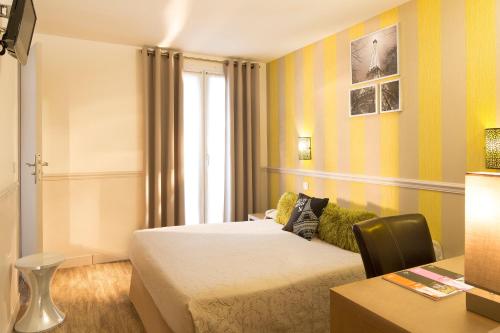 a hotel room with two beds and a desk at Hotel De La Cite Rougemont in Paris