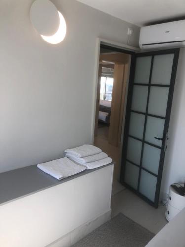 a bathroom with white towels on a counter and a mirror at kolonaki Penthouse panoramic Acropolis view in Athens
