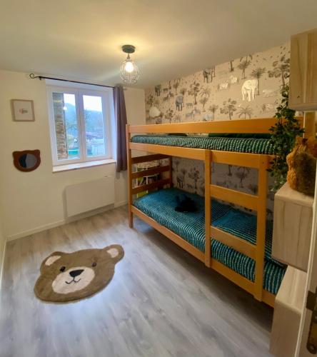 - une chambre avec 2 lits superposés et un tapis en peluche dans l'établissement Chez lyseha et André, à Saint-Claude