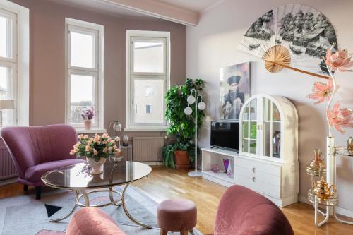 Una sala de estar con una mesa y sillas y un televisor. en Lovely Vintage Suite, autohalli, en Helsinki