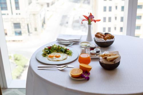 a table with plates of breakfast food on it at Dusit Doha Hotel in Doha