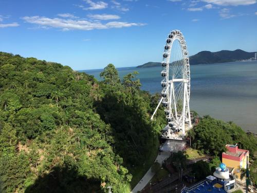 a large ferris wheel in the middle of a river at Apartamento Studio Superior com vista da BIG Wheel in Balneário Camboriú