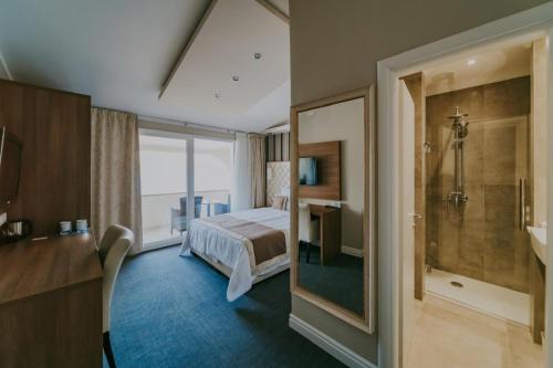 a hotel room with a bed and a shower at Bellevue Rooms in Stara Baška