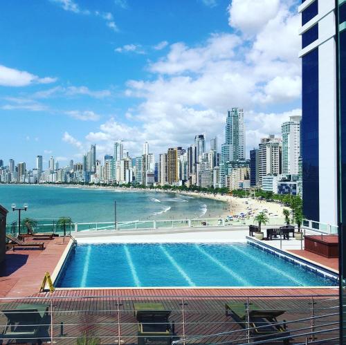 a swimming pool with a view of a city at Apartamento Studio Superior com vista da BIG Wheel in Balneário Camboriú