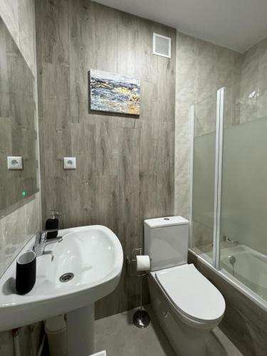 a bathroom with a white toilet and a sink at SOLMAR Playa Gandia SOLO FAMILIAS in Playa de Gandia