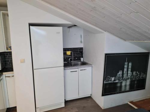 a kitchen with a white refrigerator and a sink at Ugglegatan 17 - Två rum & kök in Linköping
